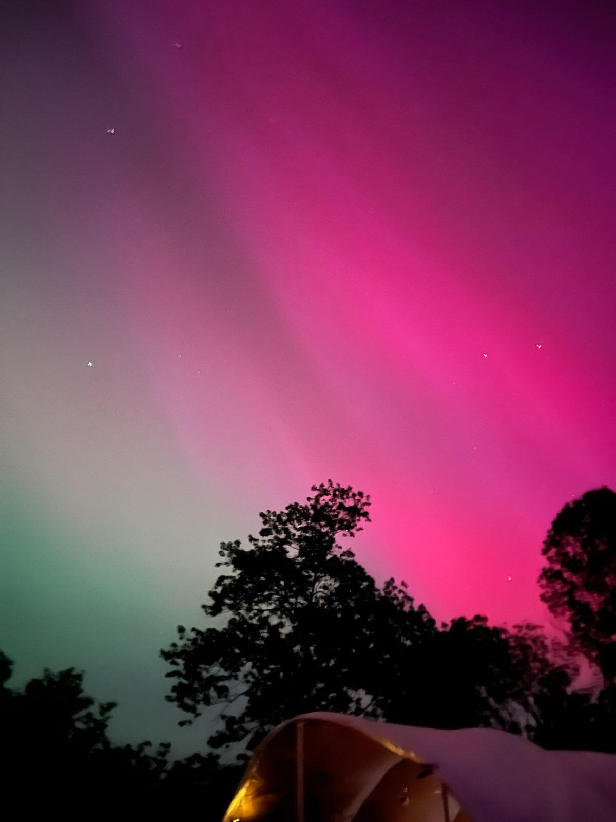 The northern lights over a theme camp structure at Xmas Burn 2024